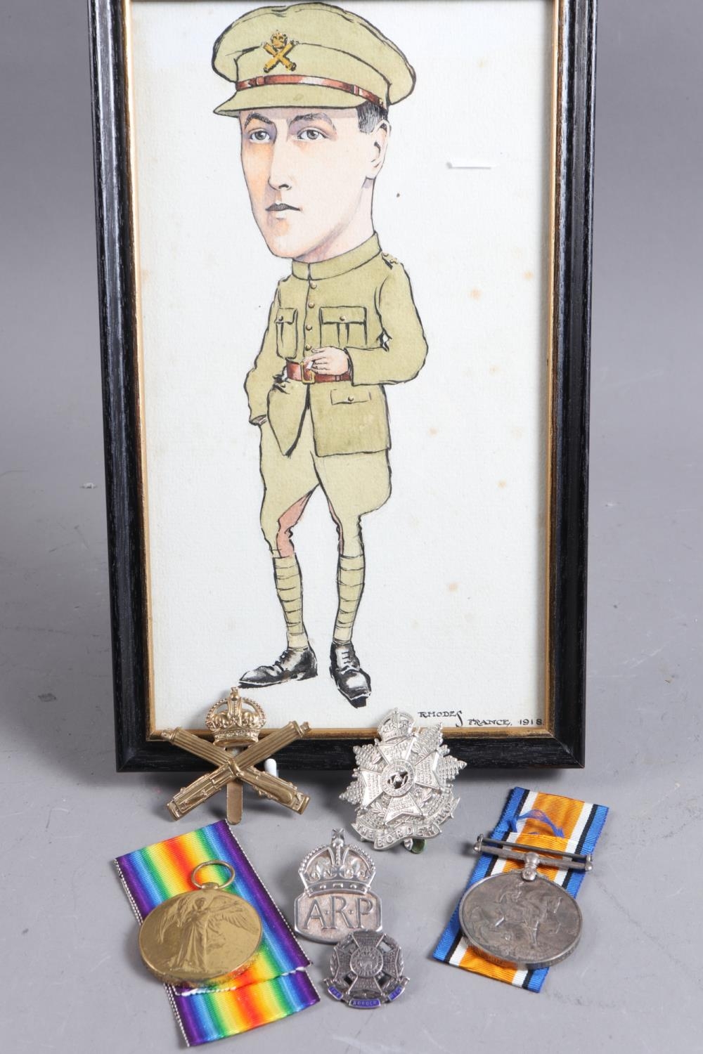Two WWI medals, awarded to Private T B Todd, together with two regimental cap badges and watercolour