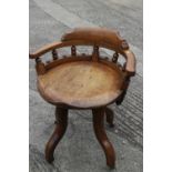 A 1920s carved hardwood desk chair, on four castored supports