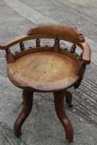 A 1920s carved hardwood desk chair, on four castored supports