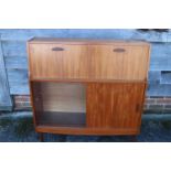A 1960s Doncraft teak desk/cocktail cabinet with two fall front compartments over one glass and