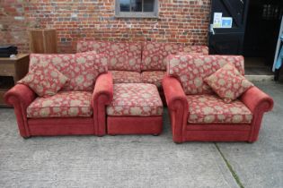 A four-seat settee with loose seat and back cushions, a pair of matching armchairs and two stools