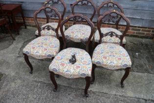 A set of six Victorian carved walnut loopback dining chairs with stuffed over seats, on cabriole