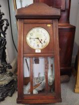 A 1930s oak cased wall clock with eight-day striking movement, 31" high, and a Smith's metal