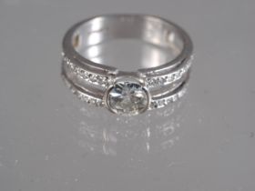 An 18ct white gold dress ring, set central diamond and diamond shoulders, size Q, 6.1g