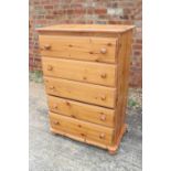 A pine chest of five drawers with knob handles, on bun feet, 30" wide x 17 1/2" deep x 45" high