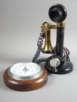 An early 20th century stick telephone and an aneroid barometer