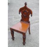 A 19th century carved oak hall chair with Gothic blind fret back and panel seat, on turned supports