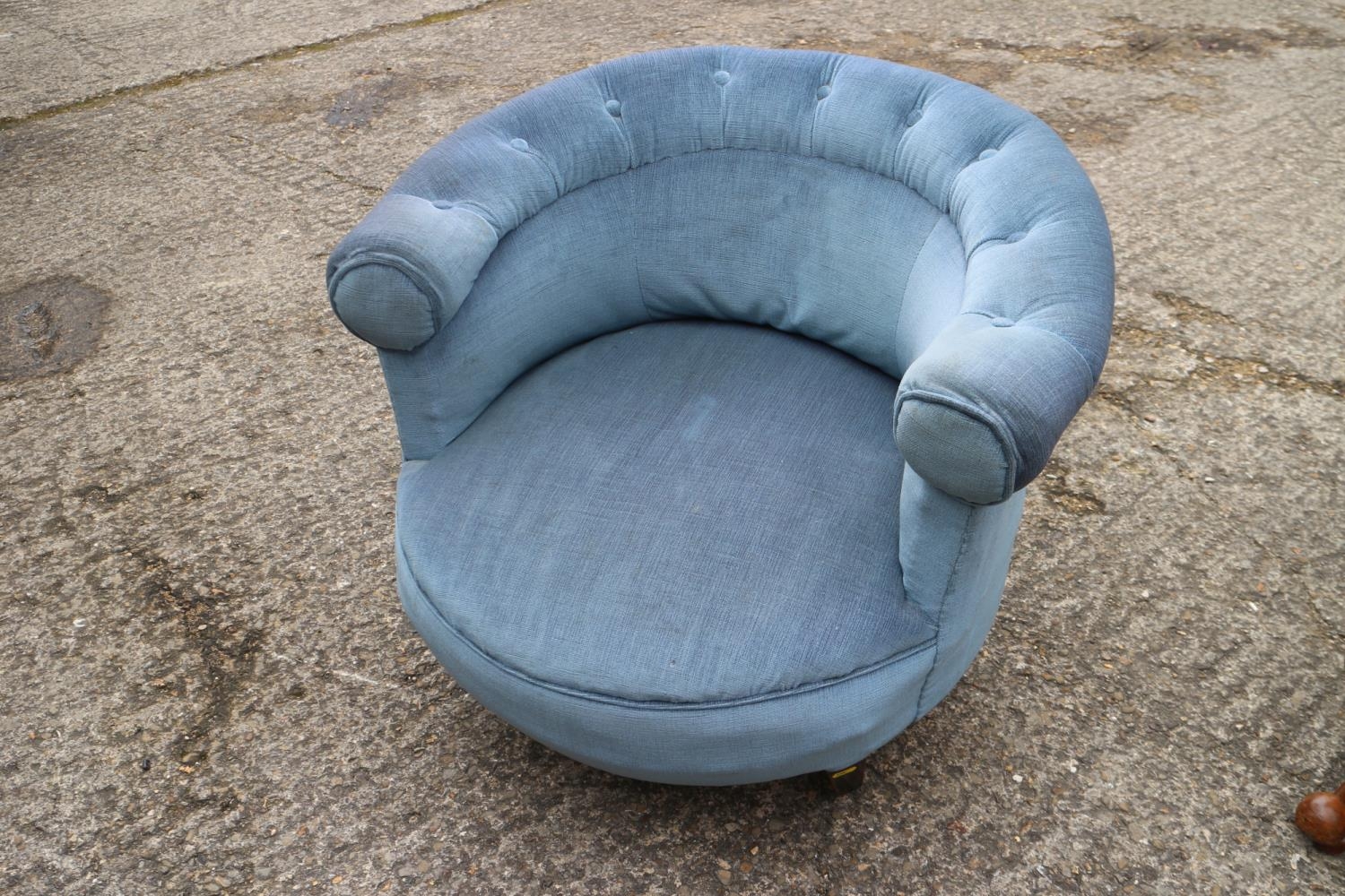 A tub shape low seat occasional chair, upholstered in a blue fabric, on square taper supports