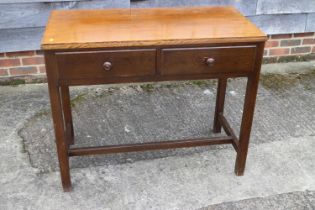 A 1960s oak side table, fitted two drawers, on moulded stretchered supports, 39" wide x 19" deep x