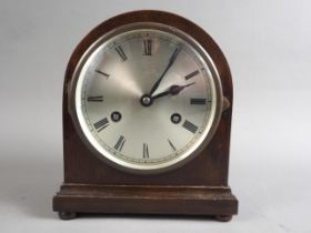 An early 20th century oak cased mantel clock with a silvered dial and eight-day striking movement,