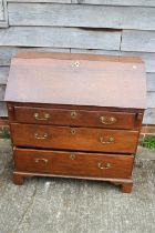 An early 20th century oak fall front bureau, the interior fitted cupboard, drawers and pigeon holes,