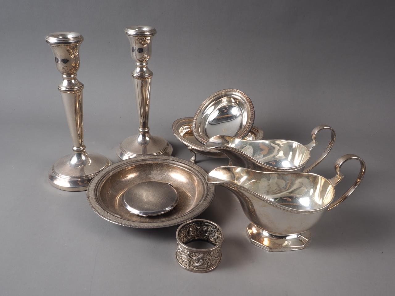 A pair of silver sauce boats, a pair of silver candlesticks, an Egyptian silver shallow dish, two .