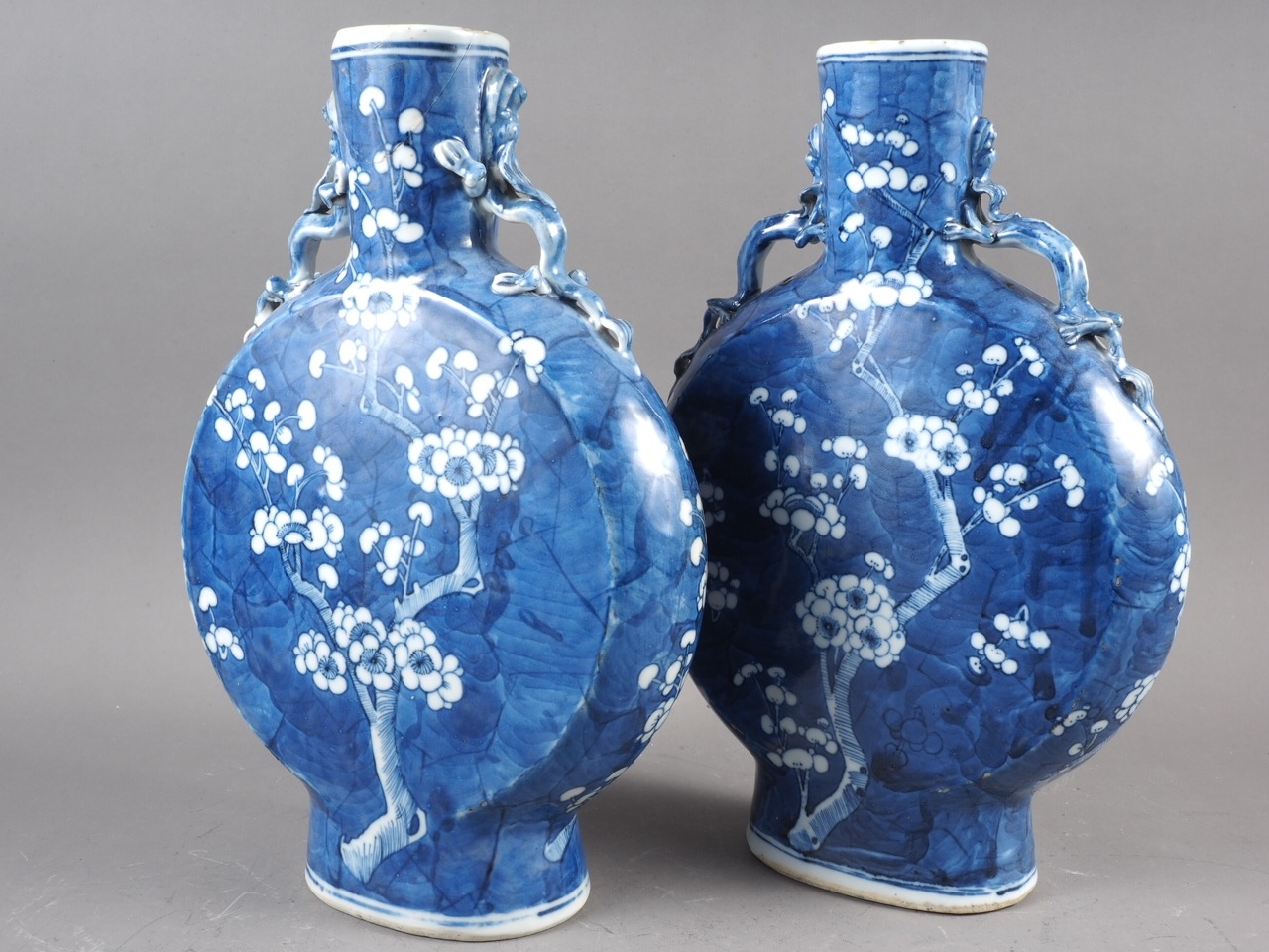 A pair of Chinese blue and white moon flasks with relief dragon handles and prunus decoration, - Image 3 of 27