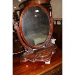 A 19th century figured mahogany oval swing frame toilet mirror, on plateau base with jewel