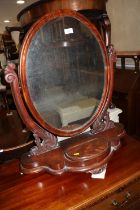 A 19th century figured mahogany oval swing frame toilet mirror, on plateau base with jewel