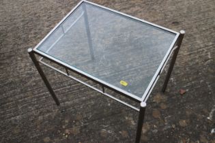 A brushed chrome framed glass top coffee table, 44" wide x 24" deep x 18" high, and a companion lamp