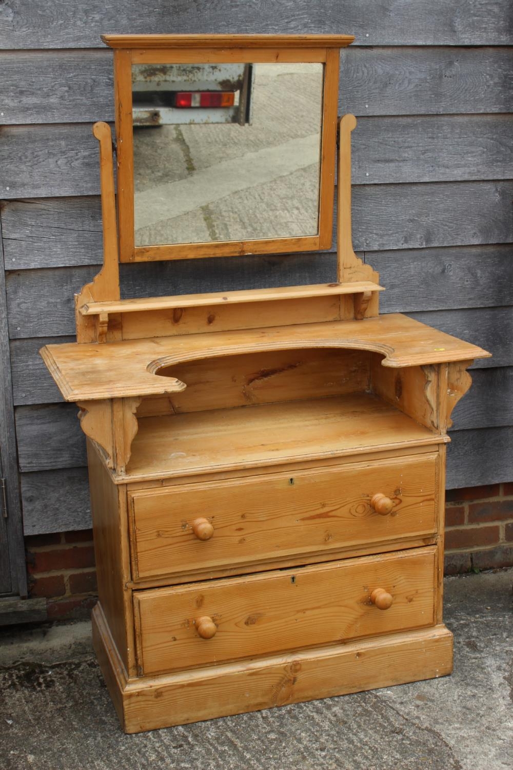 A waxed pine dressing chest, fitted mirror over shaped top, two drawers and two long drawers, on
