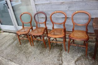 A set of four polished as walnut cane seat bedroom chairs, on turned splay supports