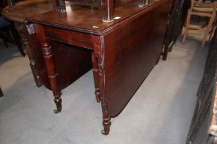 A 19th century mahogany drop leaf dining table, on turned and castored supports, 62" wide x 42" deep