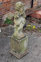 A cast stone figure of a putto playing a flute, on square base, 38" high