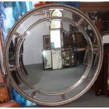 A circular bevelled edge wall mirror with sectional plate and silvered frame, 44" dia