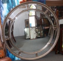 A circular bevelled edge wall mirror with sectional plate and silvered frame, 44" dia