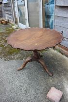 A Georgian mahogany single-piece pie crust tilt-top table, on spiral turned column, on carved