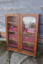 An oak display cabinet enclosed two shape top glazed panel doors, 31" wide x 8 1/2" deep x 36" high