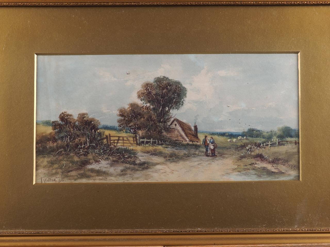 J Wilton, 1905: a watercolour landscape with cottage, figures and a sheep, 6 1/2" x 13 1/2", in gilt