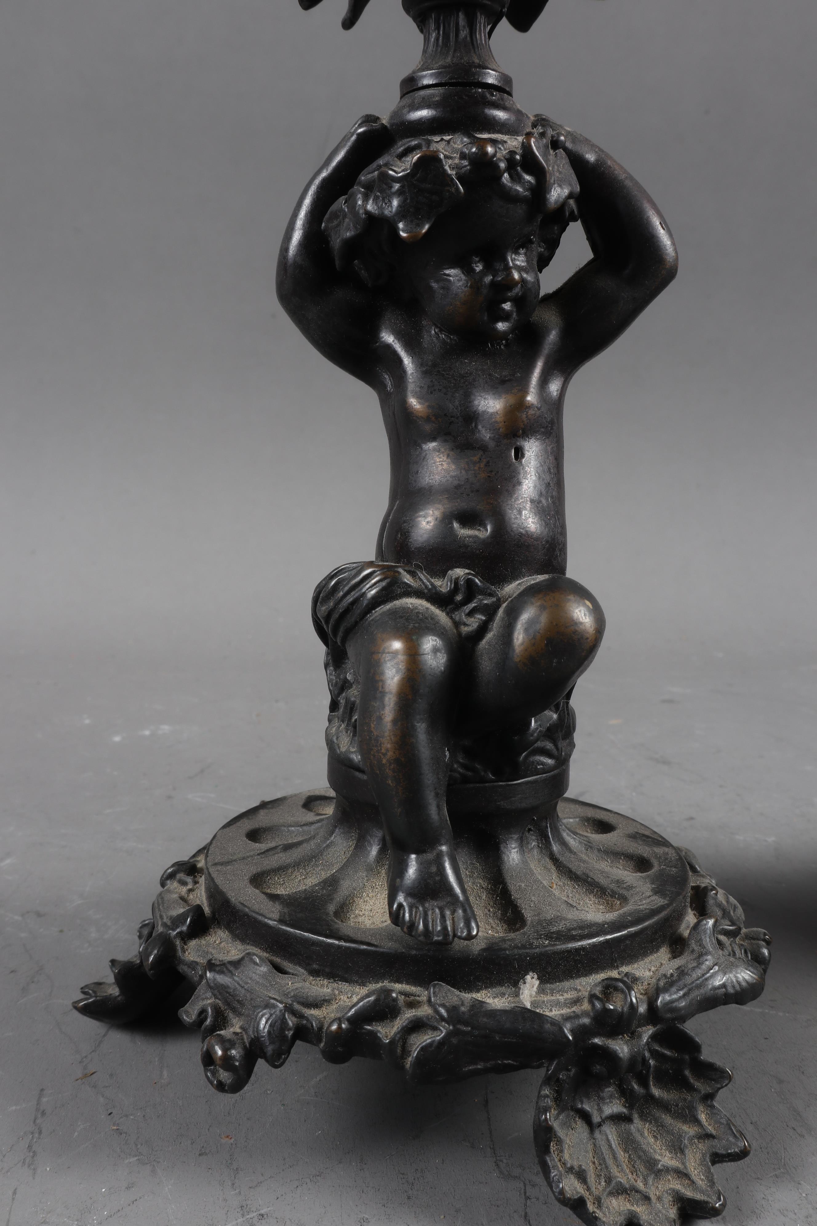 A pair of early 19th century patinated candlesticks, formed as putti, with later added ruby glass - Image 3 of 5