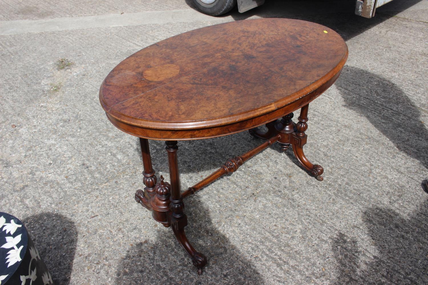 A late 19th century burr walnut oval occasional loo table, on twin turned and stretchered splay