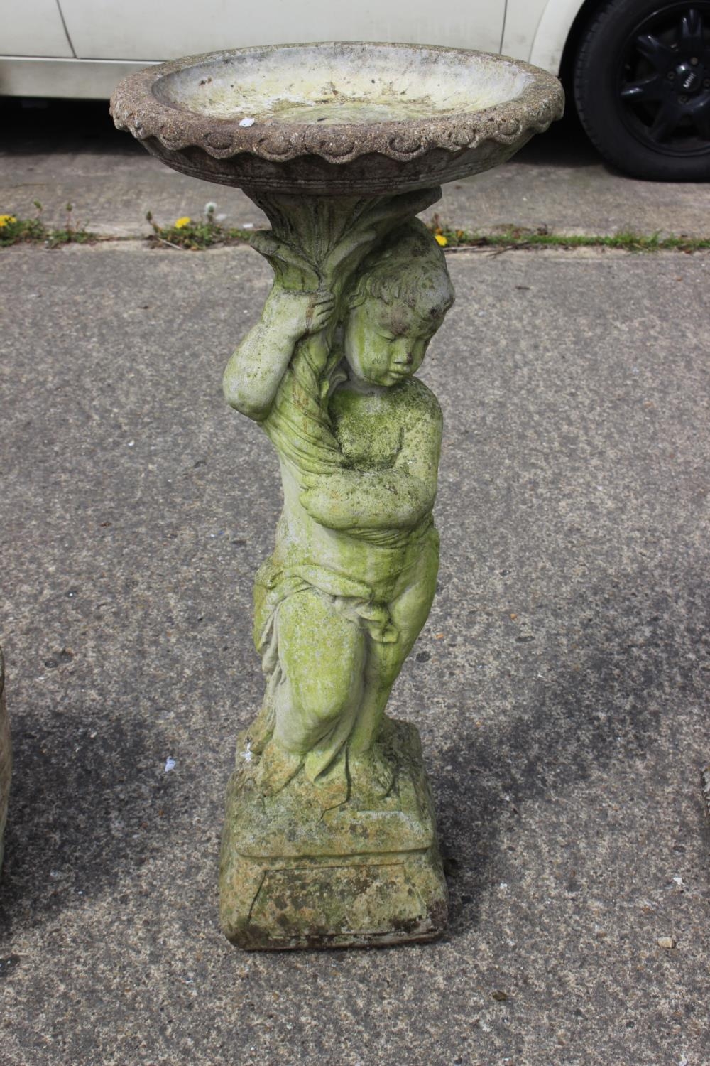 A cast stone bird bath with putto support, 14" dia x 34 1/2" high