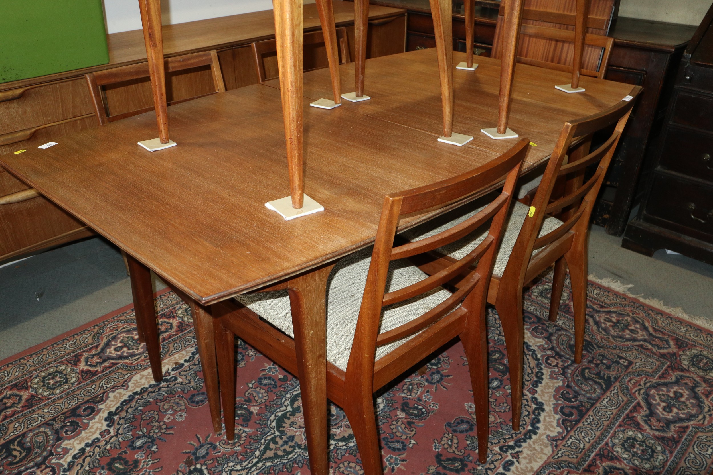 A 1960s McIntosh teak extending dining table, 78" wide x 36" deep x 29" high, and a set of seven