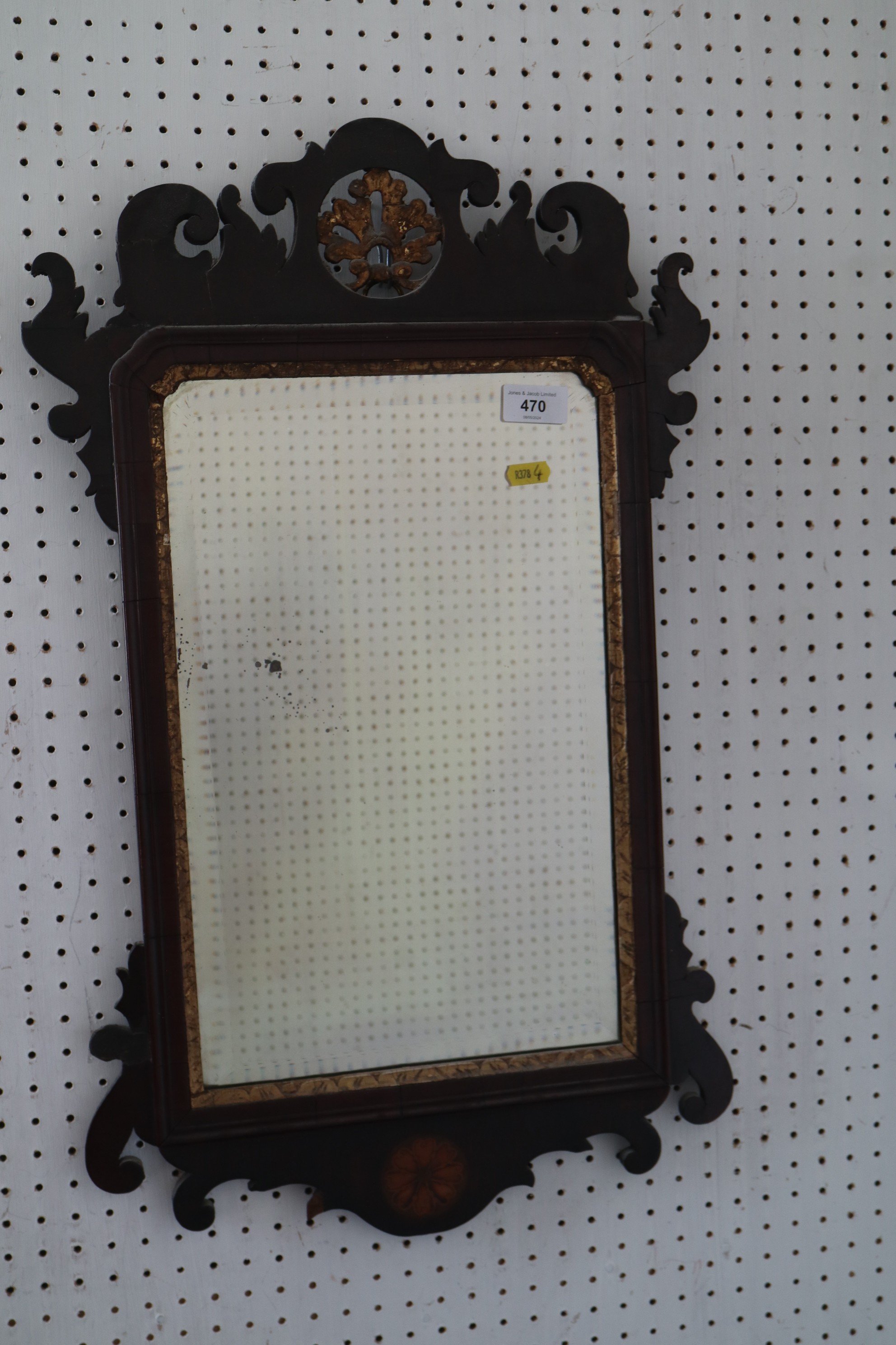 A walnut framed wall mirror of early 18th century design with pierced and gilt crest and bevelled