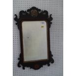 A walnut framed wall mirror of early 18th century design with pierced and gilt crest and bevelled
