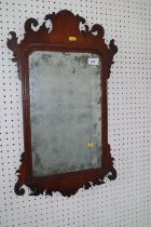 A walnut framed wall mirror of early 18th century design with shaped crest and plate, 24" high