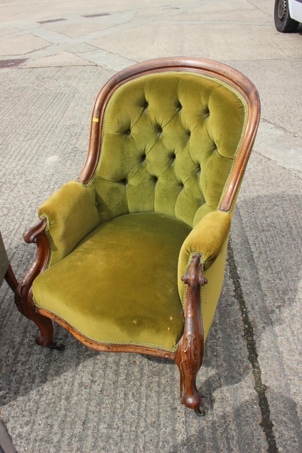 A late Victorian carved walnut showframe low seat salon chair with padded seat and back, on cabriole