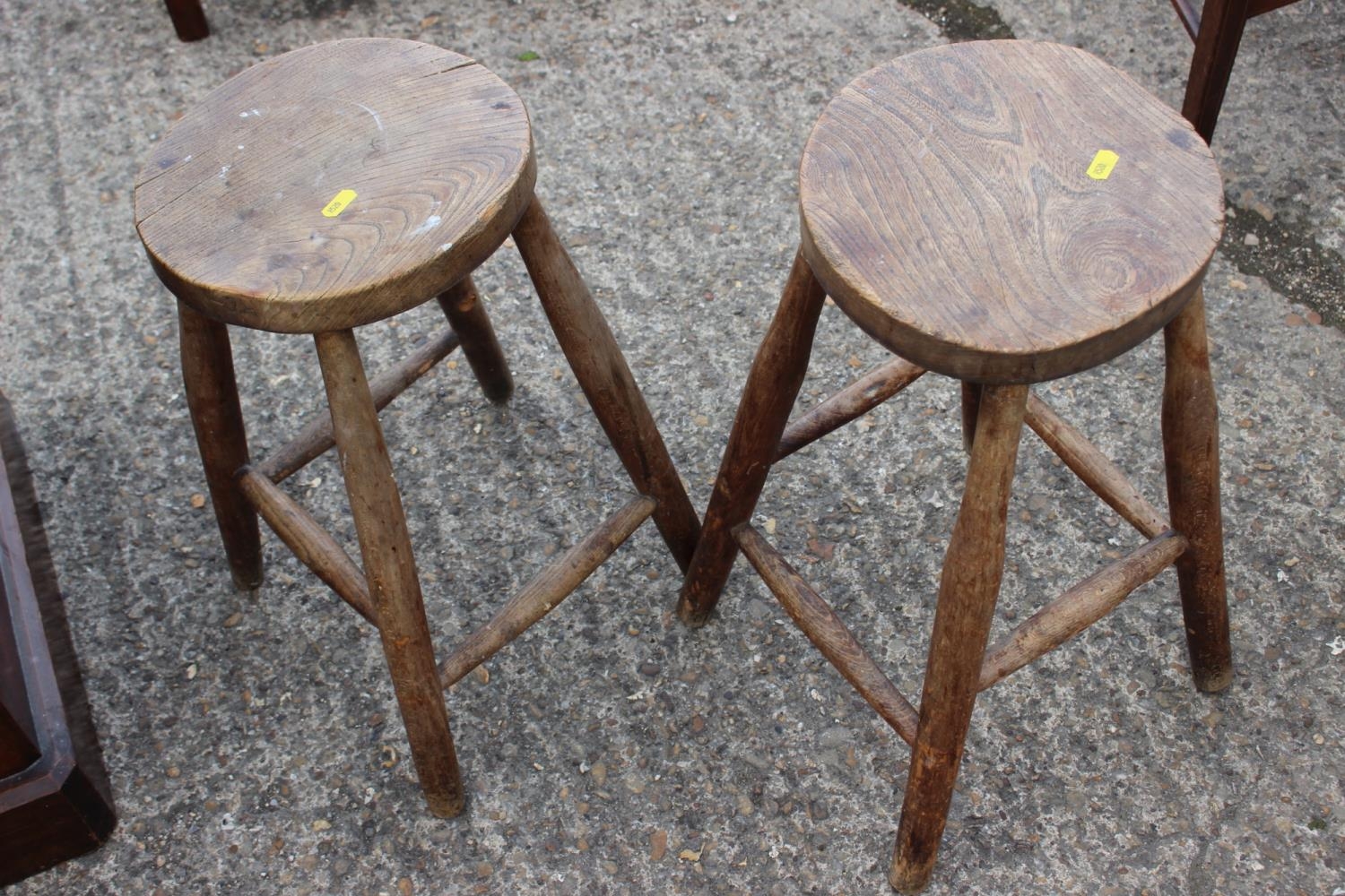 A pair of oak stools with elm tops, another smaller similar stool and two others
