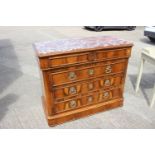 A Continental walnut chest of four long graduated drawers with carved wooden handles and marble top,