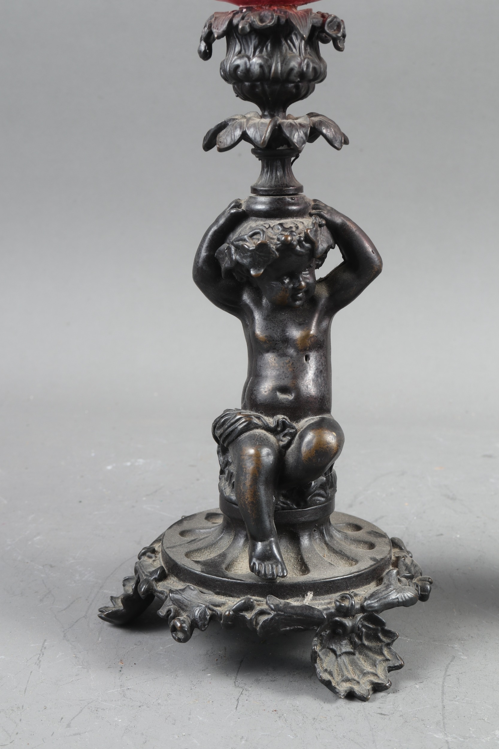 A pair of early 19th century patinated candlesticks, formed as putti, with later added ruby glass - Image 2 of 5