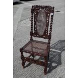 A late 17th century carved walnut side chair with oval cane back panel, cane seat and cherubim