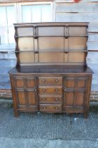 An Ercol dark elm Old Colonial dresser with three-tier plate rack over four drawers and flanking