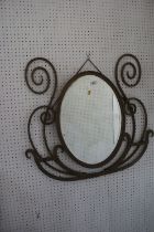 A scrolled wrought iron framed oval wall mirror with bevelled plate, 19 1/2" x 13 3/4", and a gilt