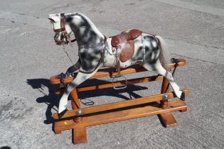 A carved wood dapple grey rocking horse, 44" wide