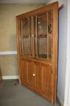 A 19th century waxed pine corner display cabinet enclosed two glazed panel doors over cupboard,