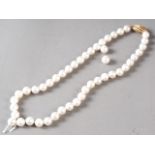 A cultured pearl single strand necklace with yellow metal, stamped 750, clasp, set diamonds,