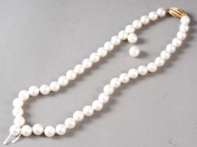 A cultured pearl single strand necklace with yellow metal, stamped 750, clasp, set diamonds,
