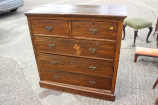 An Edwardian walnut chest of two short and three long drawers with canted corners, on block base,