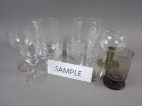 A collection of engraved glasses, brandy balloons, lager glasses, etc