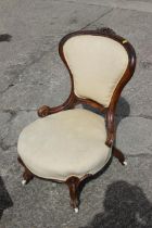 A late Victorian showframe low seat armchair, button upholstered in a green velour, on cabriole